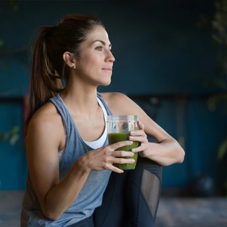 Mujer tomando un jugo verde